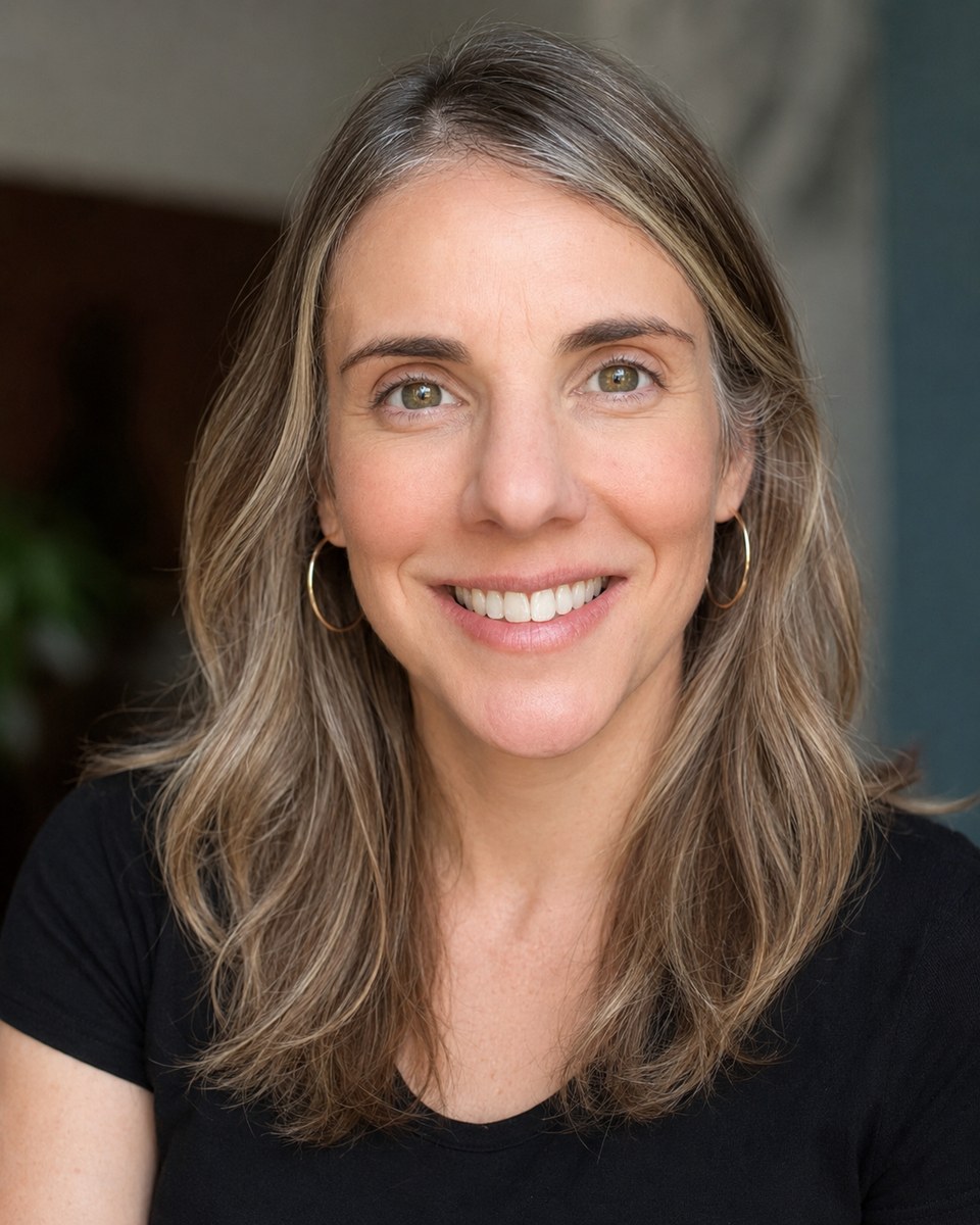 Quinn Simpson smiling in a warm portrait